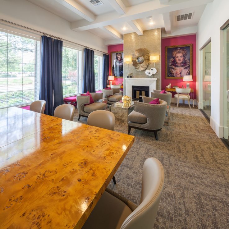 Seating area with beige chairs, wooden tables, and a fireplace