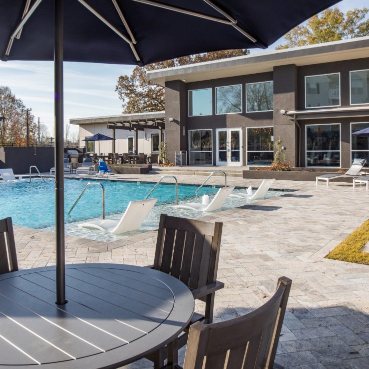 Outdoor pool with seating below umbrellas