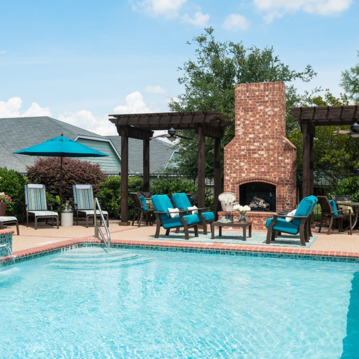 Pool in front of a seating area and brick fireplace