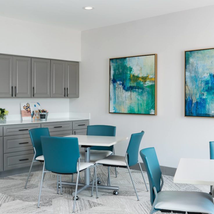 Kitchen area with dining area and abstract paintings on the wall