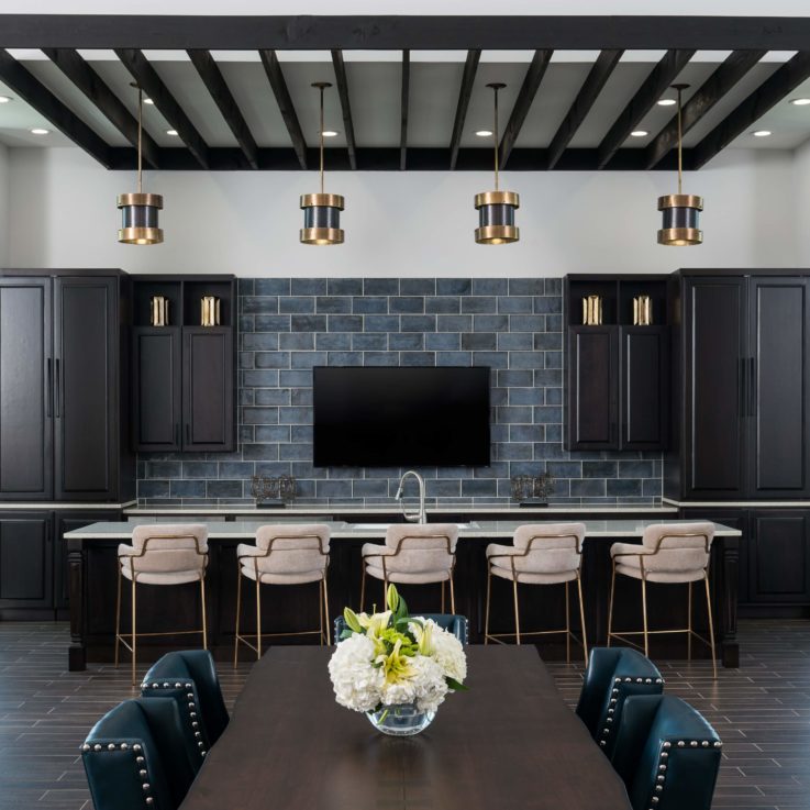 Bar seating in front of dark cabinets and a flatscreen television