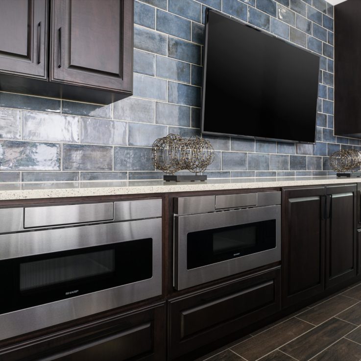 Dark cabinets, stainless steel appliances, granite countertop and flatscreen television
