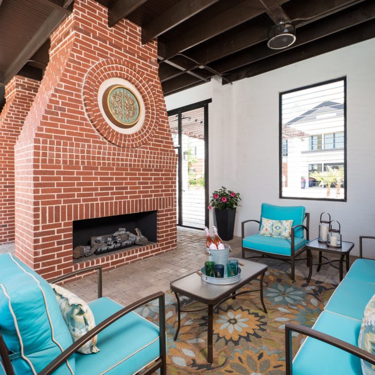 Teal seating area in front of a brick fireplace