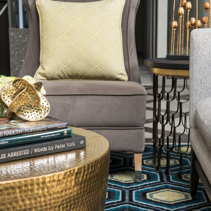 Closeup of a couch, chair, and coffee table with books