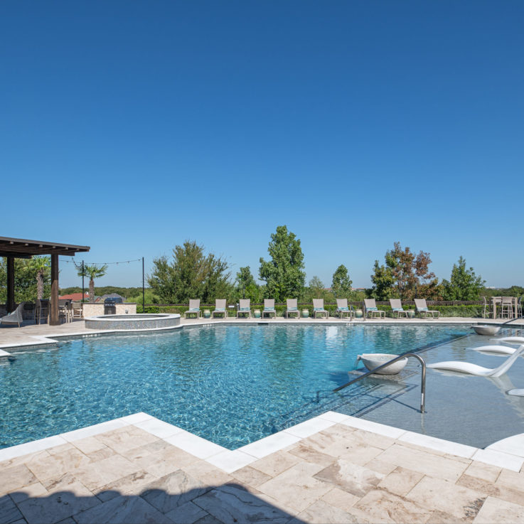 Outdoor pool with beach chairs and a covered seating area