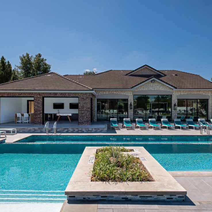 Outdoor pool with beach chairs and a clubhouse