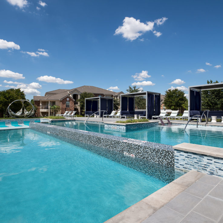 Outdoor pools with private seating areas in cabanas