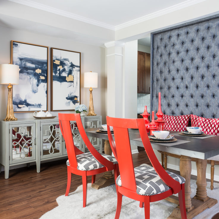 Dining room table with a bench and two orange chairs