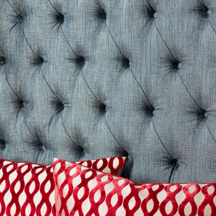 Closeup of a blue bench with orange and white pillows