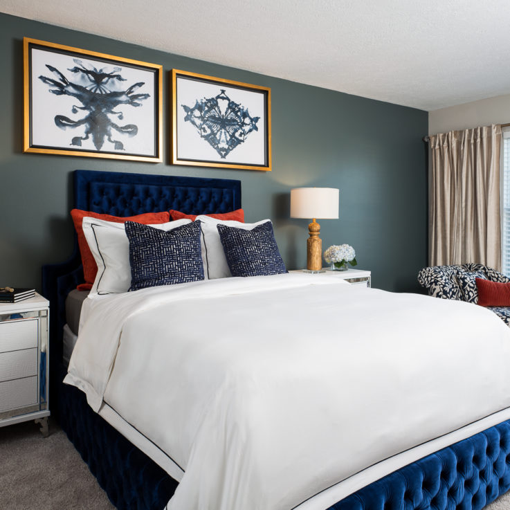 Blue bed with two nightstands against a blue gray wall
