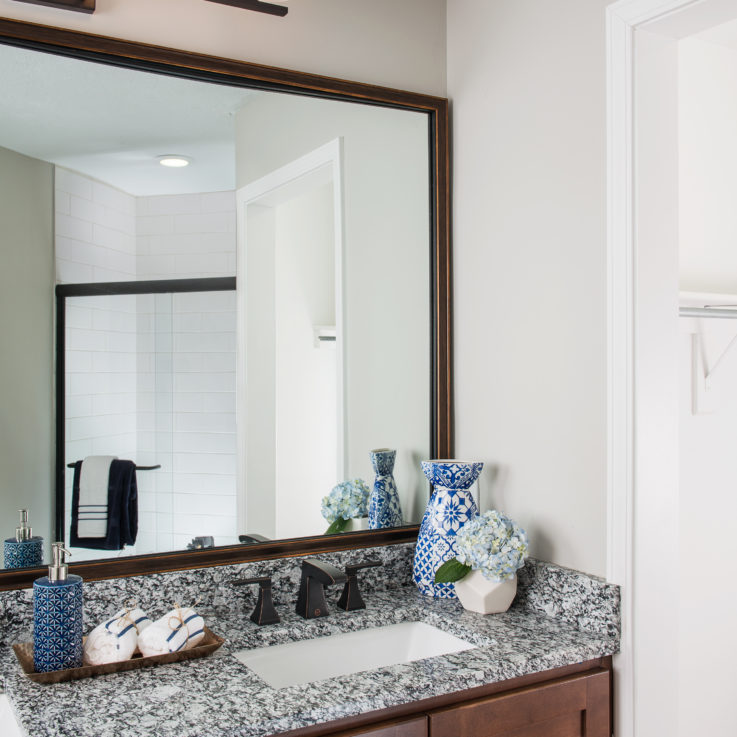 Bathroom sink with granite countertop and dark brown wood cabinets