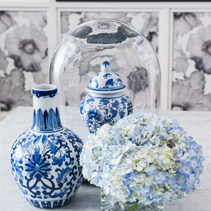 Two blue and white vases and flowers on a white table