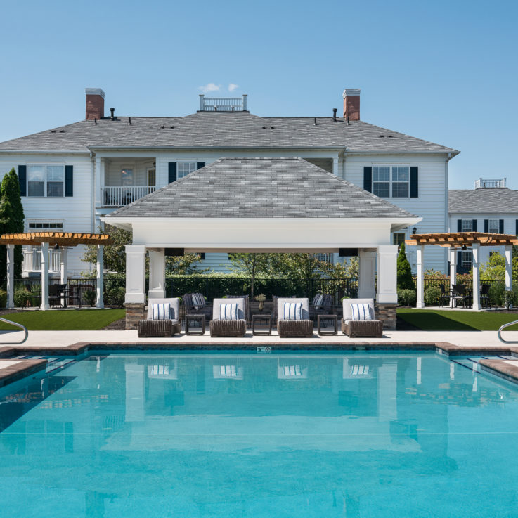 Outdoor pool beside a cabana with various seating