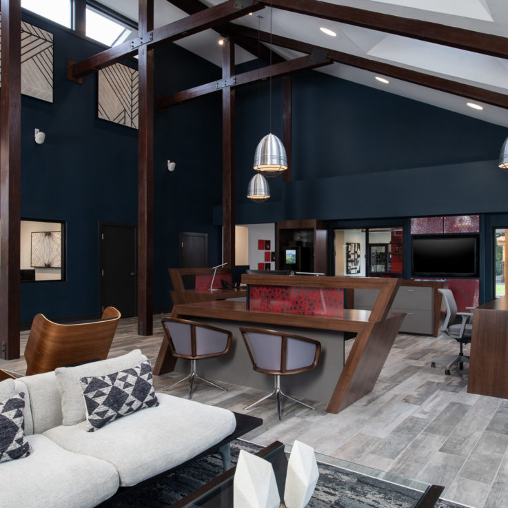 Three wooden desks in a tall room with a sloped ceiling