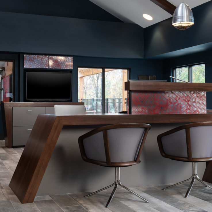 Angled wooden desk with two chairs