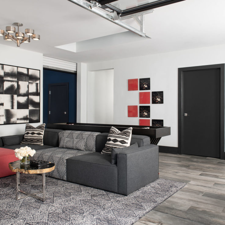 Recreation area with a dark gray couch and a table shuffleboard