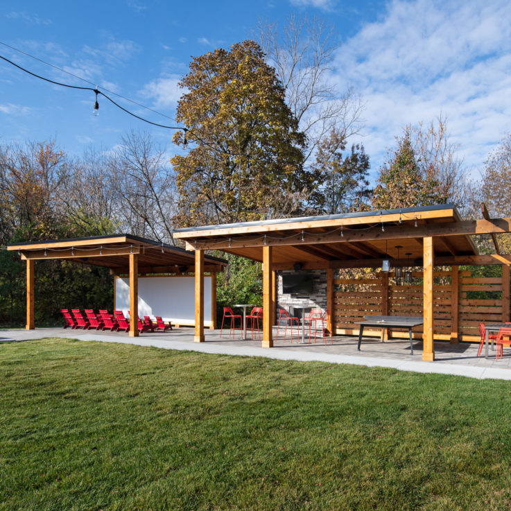 Outdoor covered seating areas with a projection screen and ping pong table