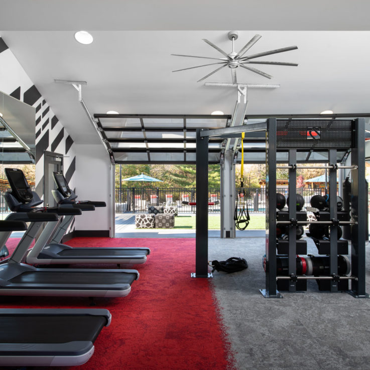 Workout room with various weights and machines open to the outside