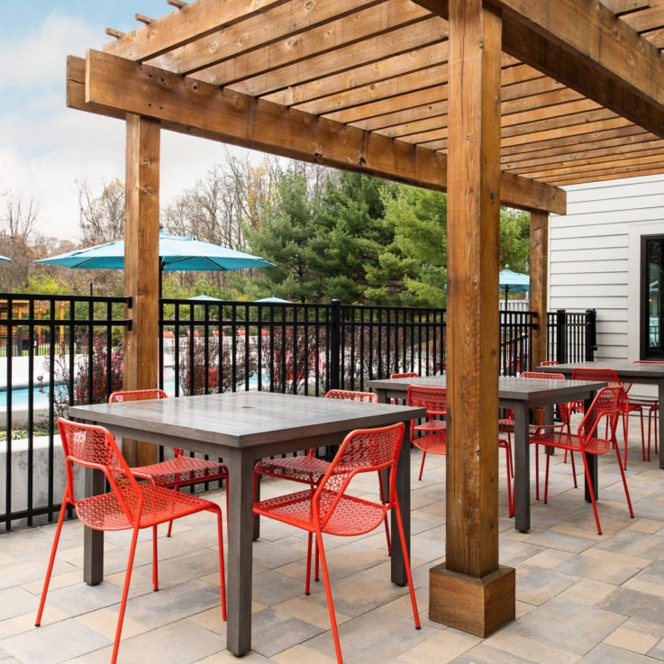 Three wooden tables each with four red chairs