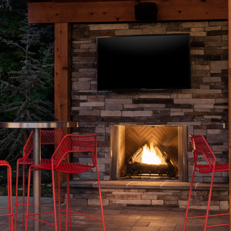 Circular tables with red chairs near a fireplace