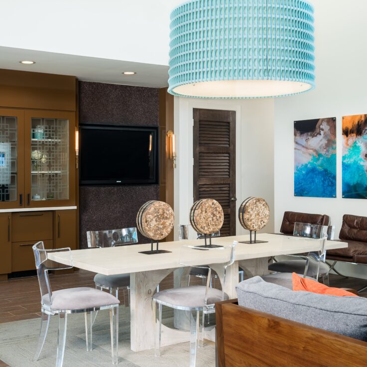 White table with clear chairs and a cabinet with a coffee maker