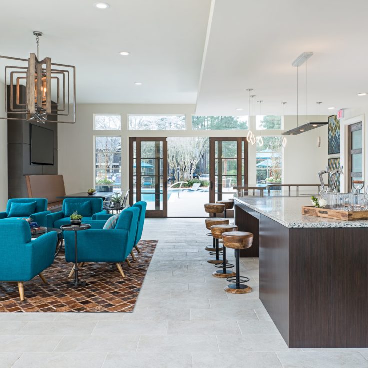 Seating area with teal chairs and wooden barstools