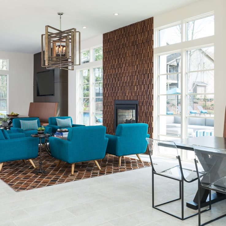 Seating area with teal chairs in front of a fireplace