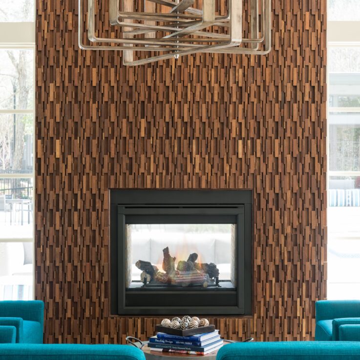 Seating area with teal chairs and a circular coffee table in front of a fireplace