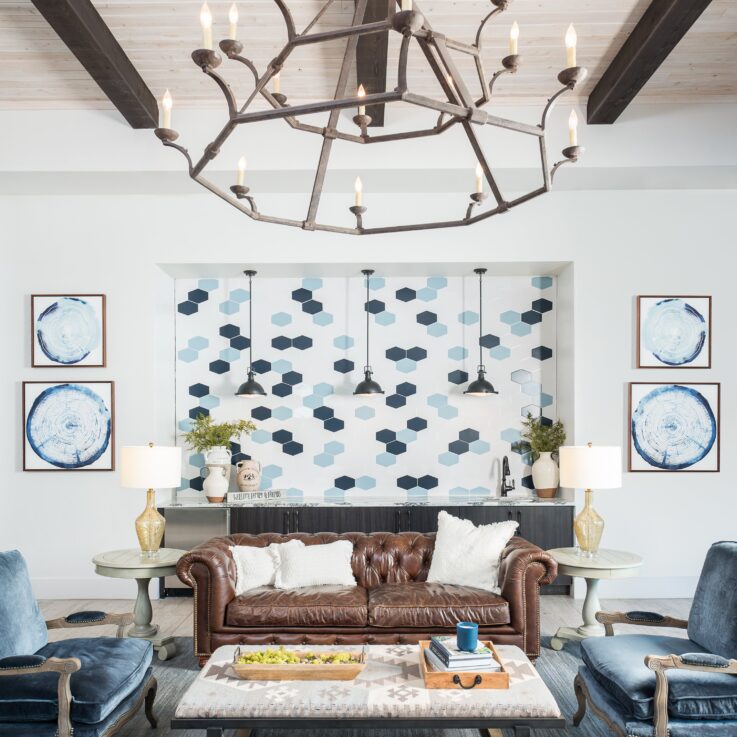 Seating area with a brown leather couch and blue cushioned chairs