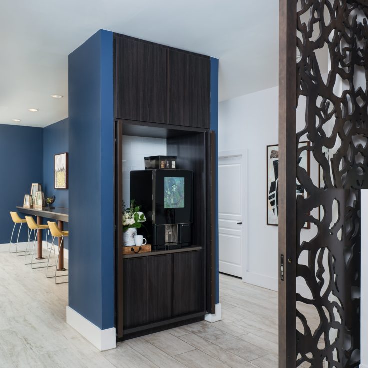 Open dark brown cabinets with a coffee maker inside