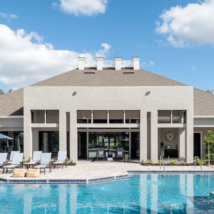 Outdoor pool with a clubhouse behind it