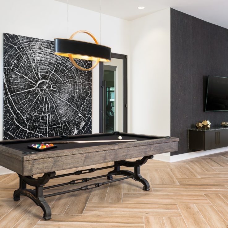 Pool table in front of black and white paintings