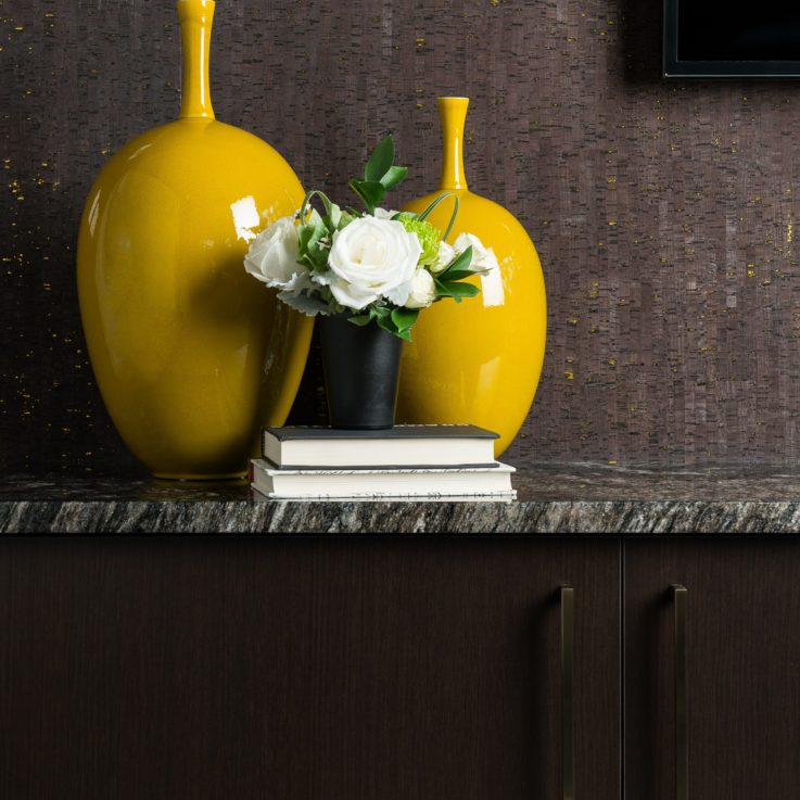 Two yellow vases on a marble countertop