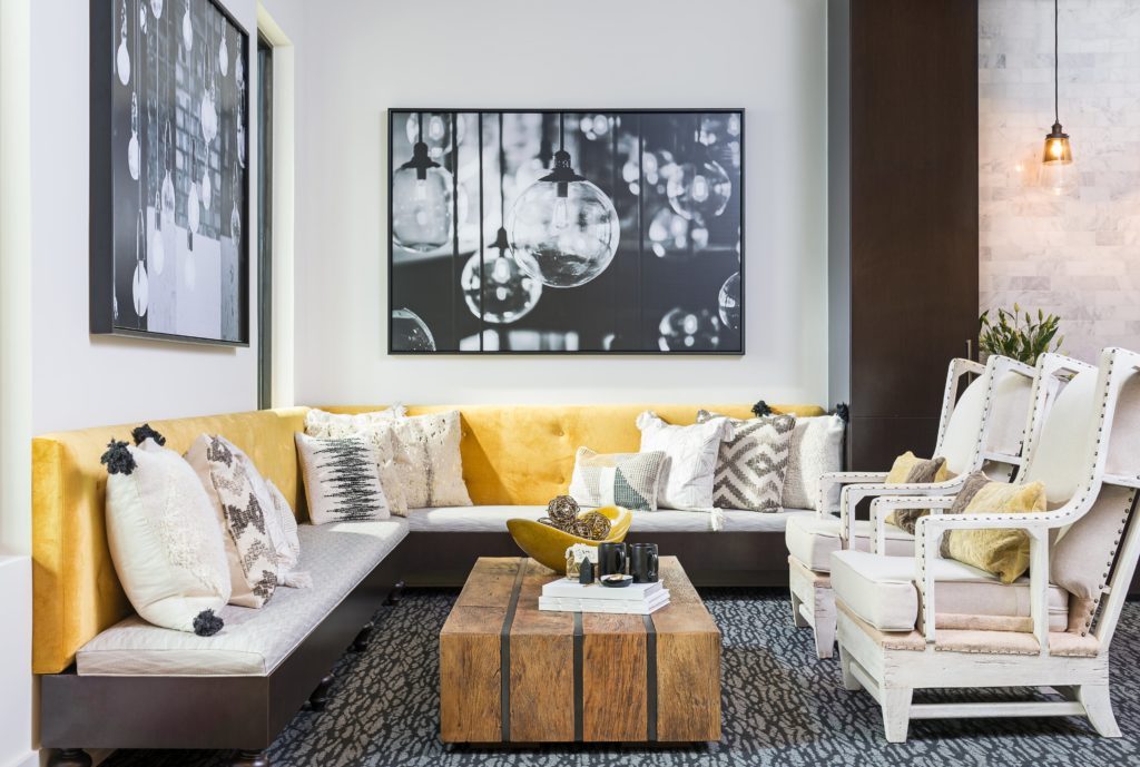 Seating area with white and yellow cushions and a wooden coffee table