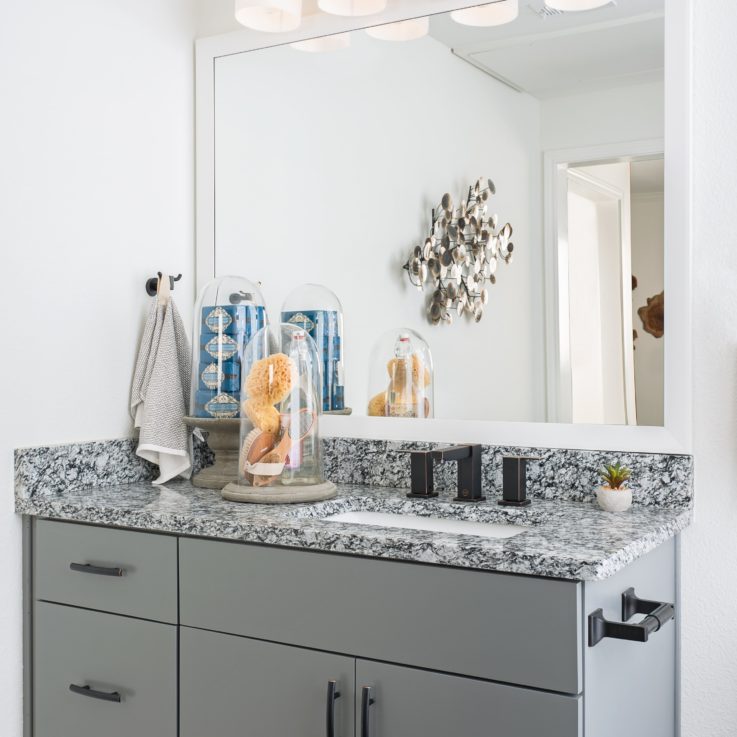 Bathroom sink with marble countertop and gray cabinets