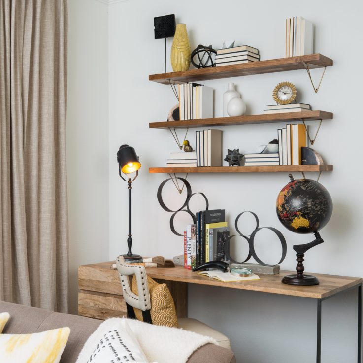 Wooden desk with a globe and wooden shelves mounted on the wall