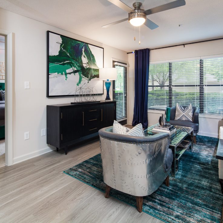 Seating area with a couch, chairs, a cabinet, and an abstract painting