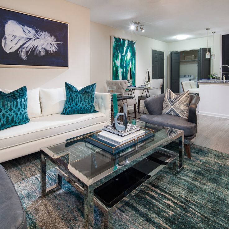 White couch, gray leather chairs, and a glass coffee table