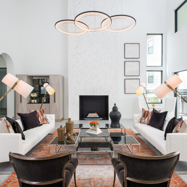 Living room with white couches, black chairs, and a fireplace
