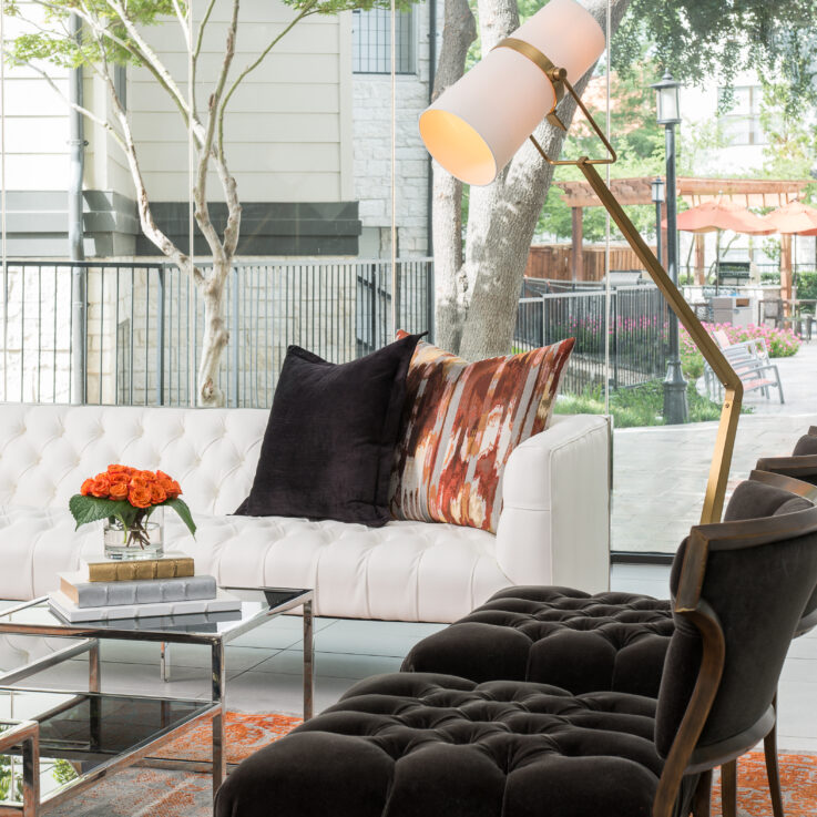 White couch and two black chairs in a living room