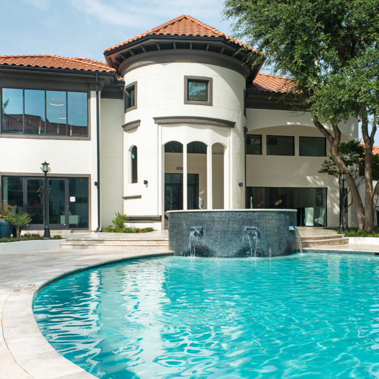 Outdoor pool with a fountain and beach chairs