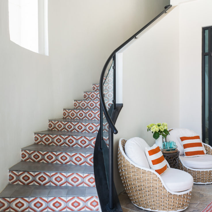 Twisting stairwell with a unique white, orange, and gray tile design
