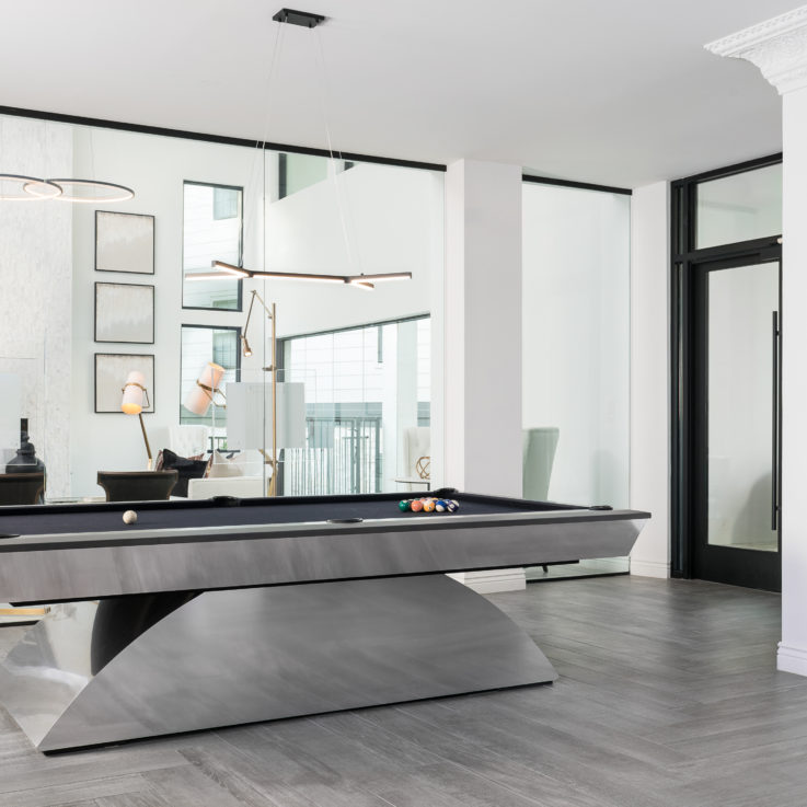 Stainless steel pool table with a glass wall behind it