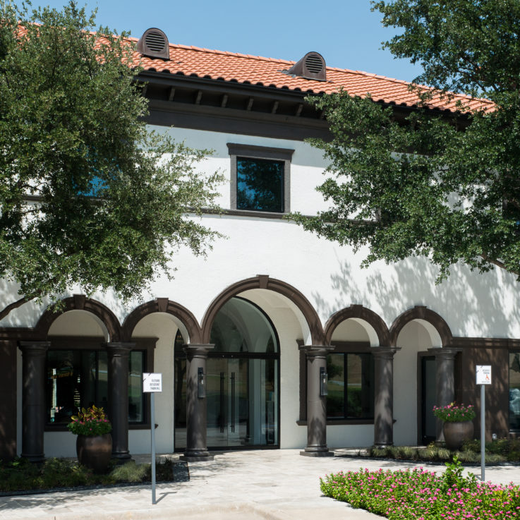 Front entrance with white walls and brown arches