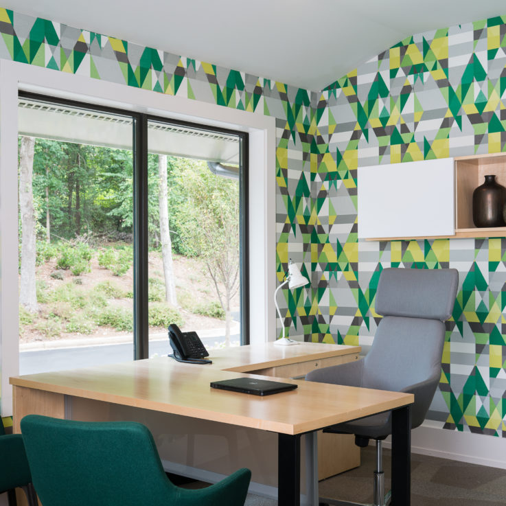 Office desk with three chairs and a window to the road