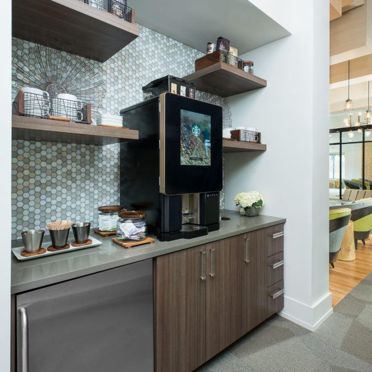 Kitchen area with a coffee maker and mini-fridge