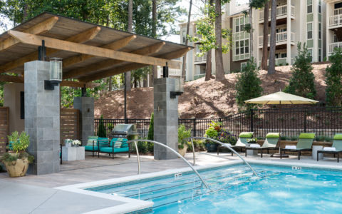 Outdoor pool with steps leading up to a covered seating area