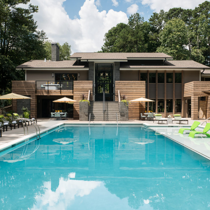 Cortland Design's Attis pool with green chairs and house behind