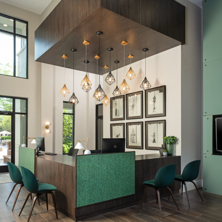 Reception area with two computers and four green chairs