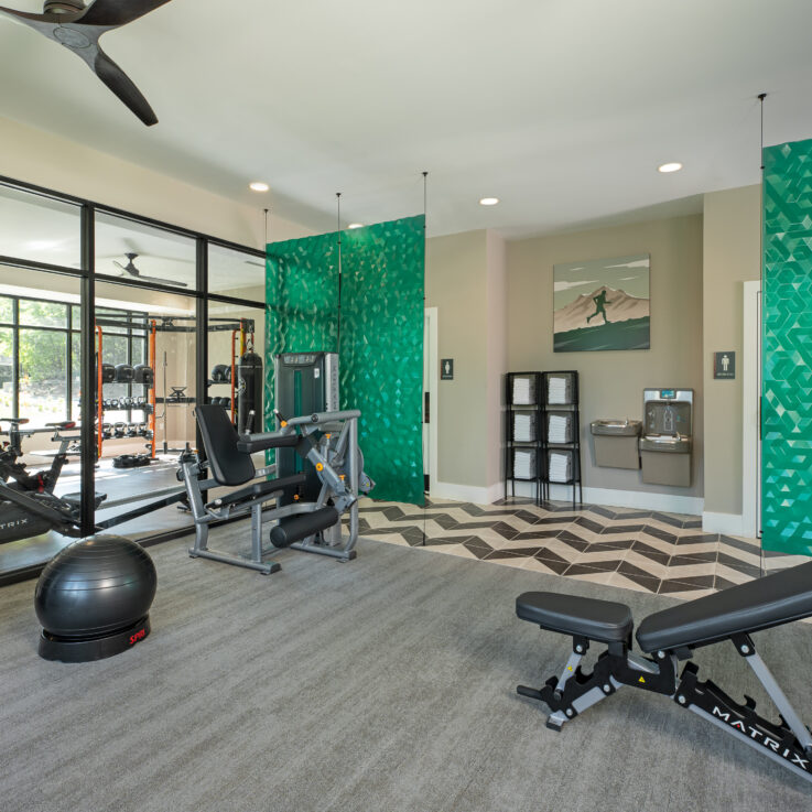 Workout room with various machines and green dividers